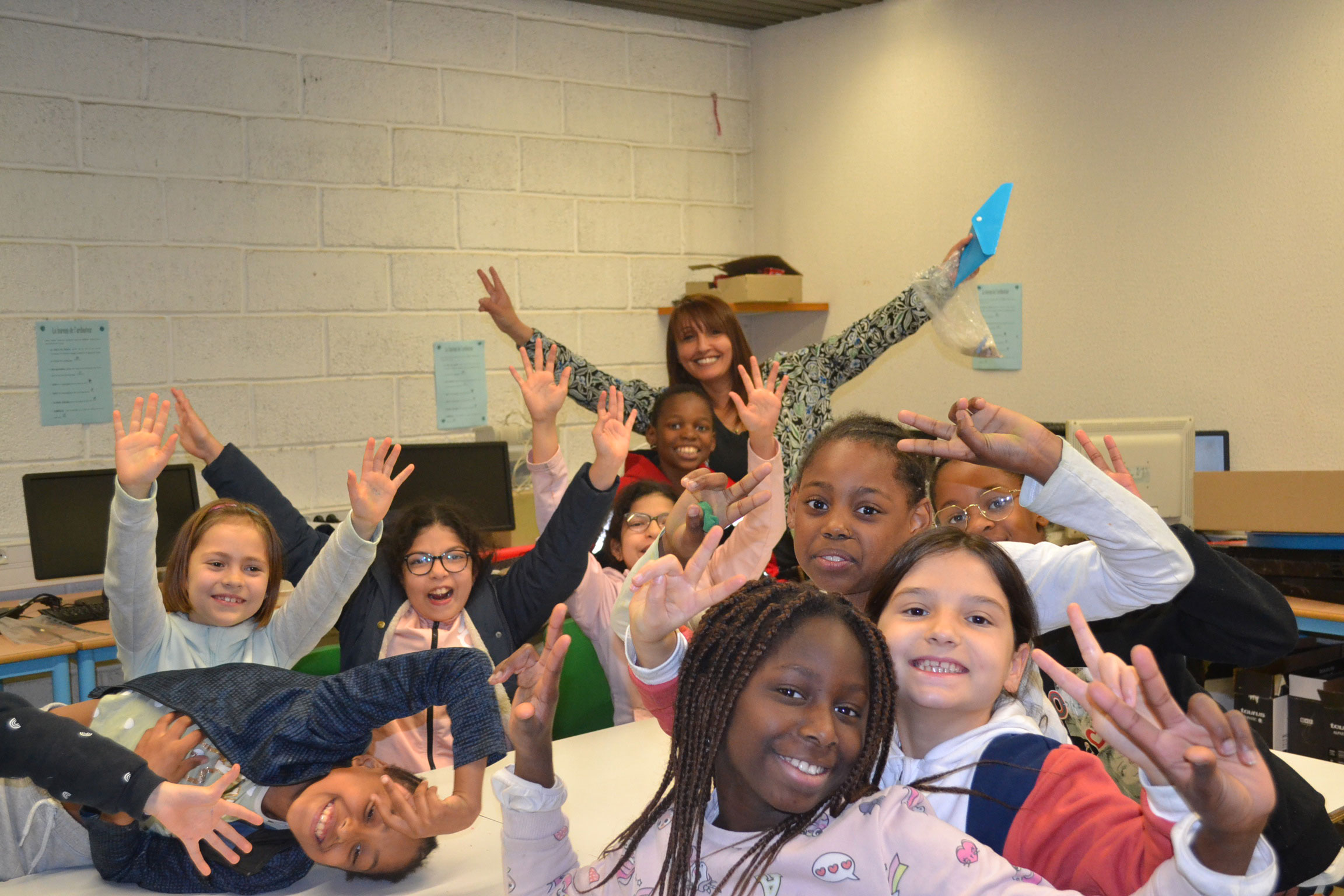 Photo de Rahima avec des enfants au premier plan lors d'un atelier