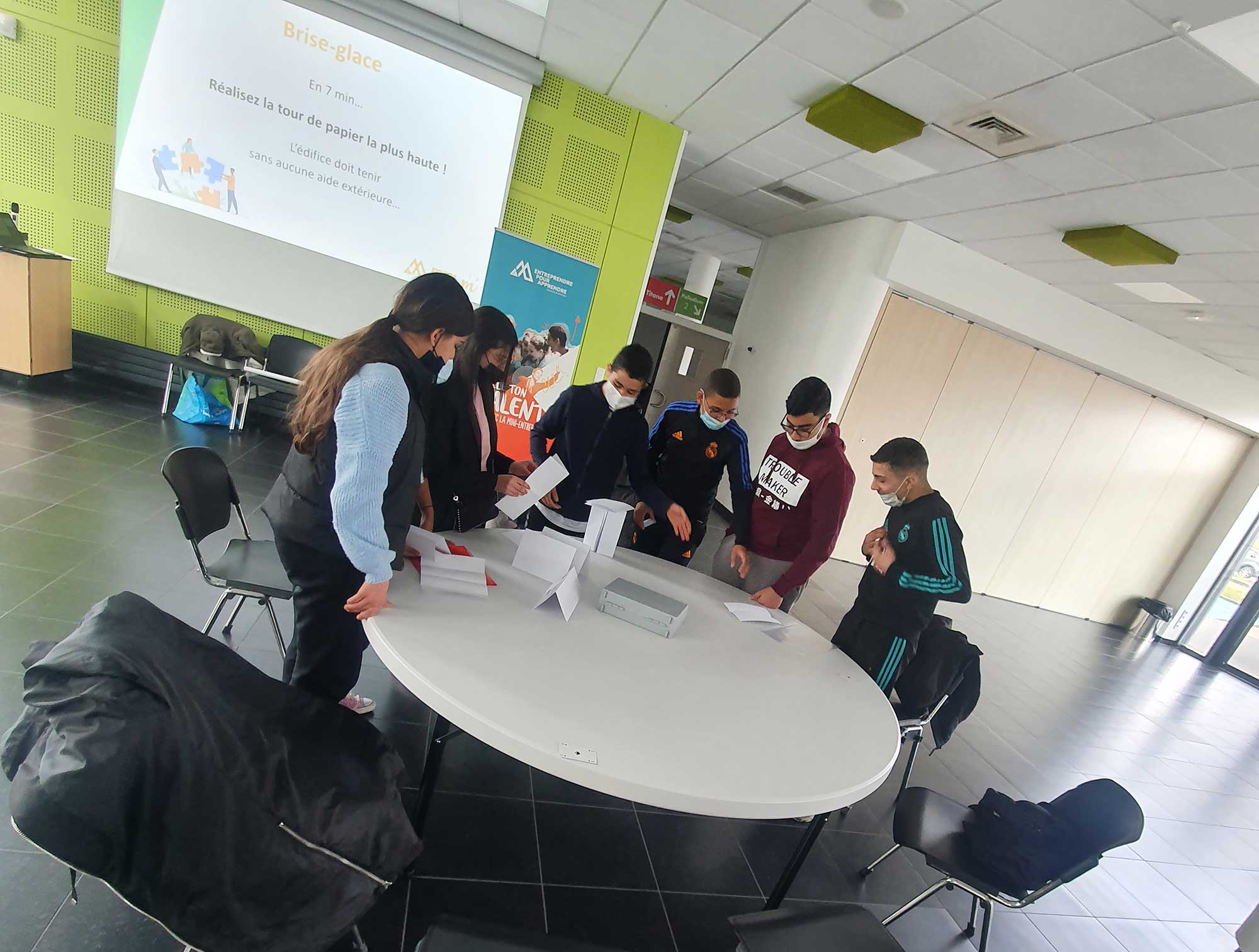 Photo de Rahima avec des enfants au premier plan lors d'un atelier